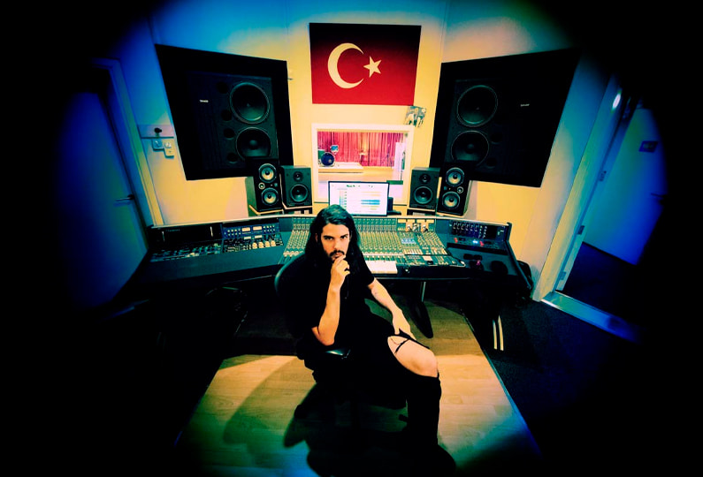 Estanislao López at Unisono music studios sitting in front of the mixing board